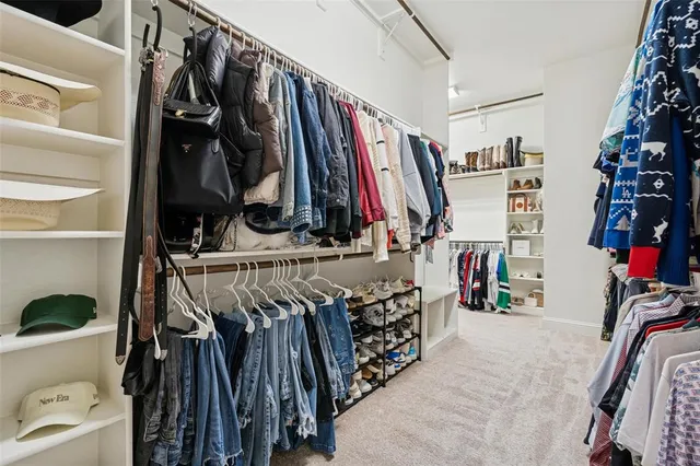 a view of walk in closet with clothes and shoes