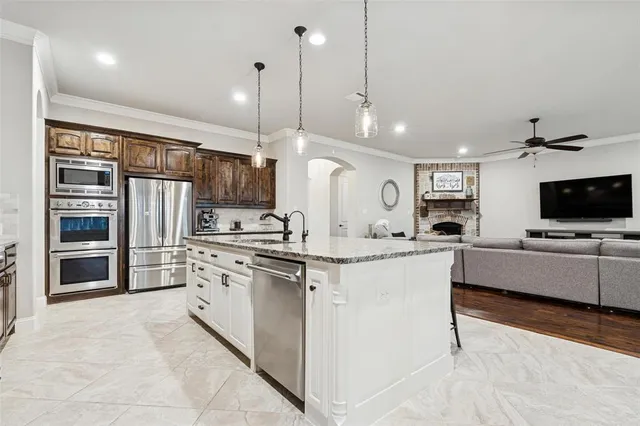 a large kitchen with stainless steel appliances kitchen island granite countertop a stove and a sink