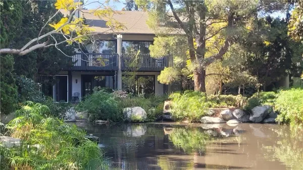 a front view of a house with a yard and a garden
