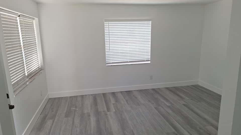 1555 Northeast 148th Street Miami, FL 33161 - Photo 12 of 14 an empty room with wooden floor and windows