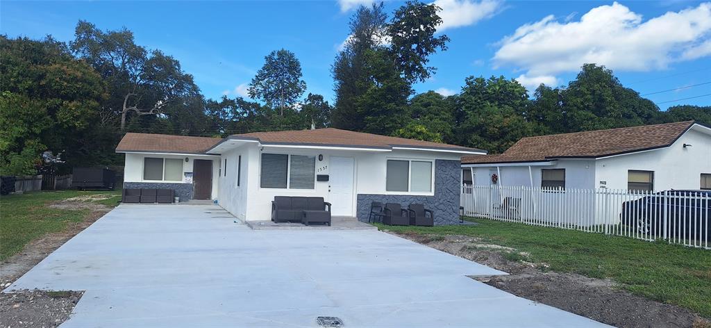 1555 Northeast 148th Street Miami, FL 33161 - Photo 2 of 14 a front view of house with yard and trees around