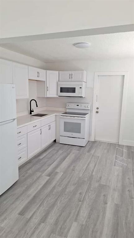1555 Northeast 148th Street Miami, FL 33161 - Photo 4 of 14 a kitchen with granite countertop white cabinets and white appliances