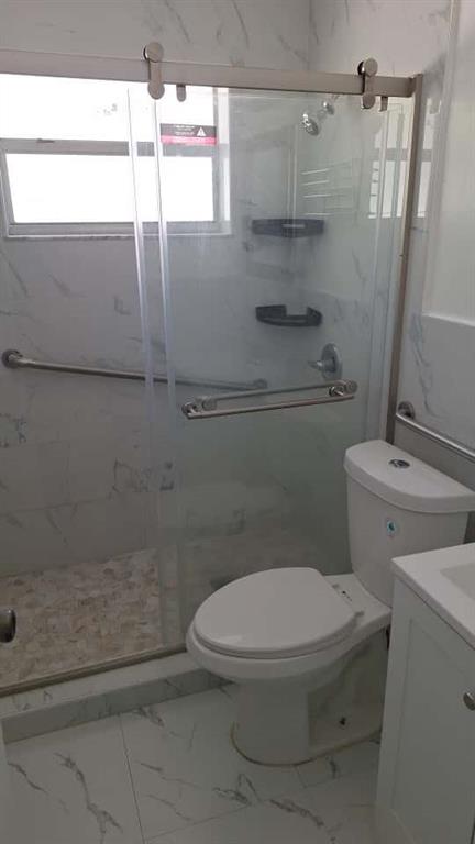 1555 Northeast 148th Street Miami, FL 33161 - Photo 8 of 14 a white toilet sitting next to a shower