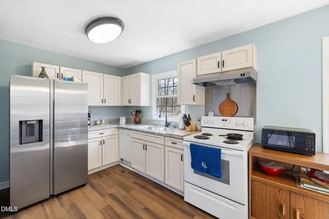 a kitchen with stainless steel appliances a stove a sink and a refrigerator