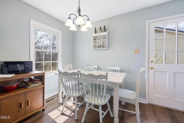 a view of a dining room with furniture a chandelier and wooden floor