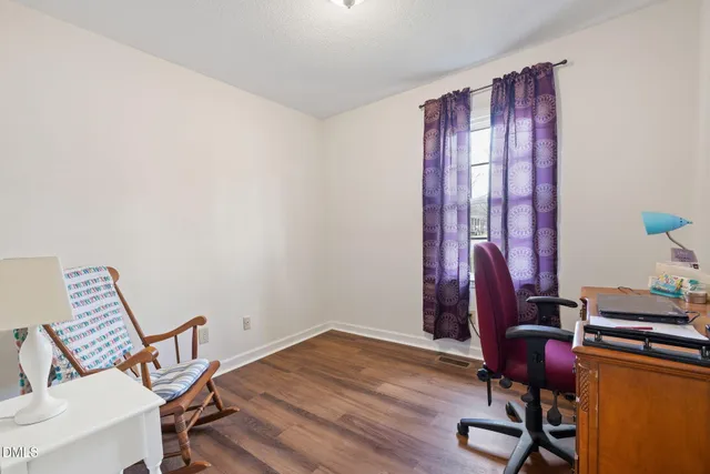 a view of a workspace with furniture and a window