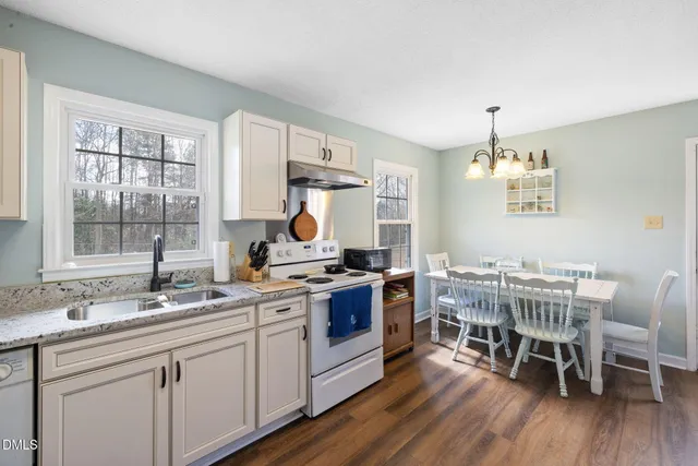 a kitchen with a table chairs stove and sink