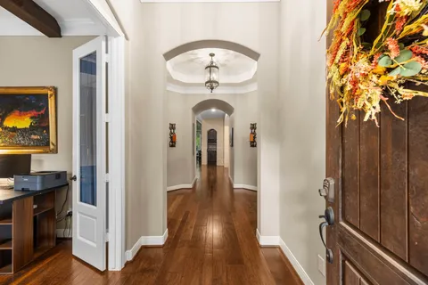 a view of a hallway with wooden floor and entryway