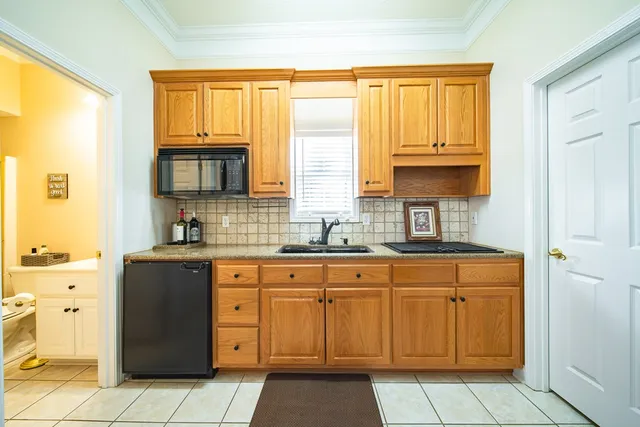 a kitchen with stainless steel appliances granite countertop a sink a stove a refrigerator and a dining table with wooden floor