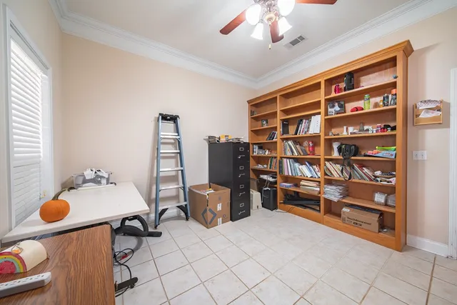 a bedroom with a bed ceiling fan and a wooden floor