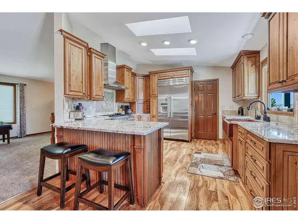 a kitchen with stainless steel appliances granite countertop a stove a sink and a refrigerator