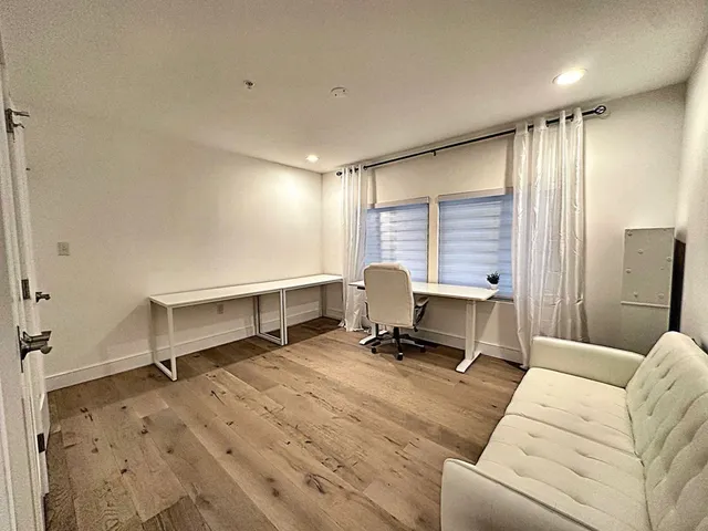 a living room with furniture gym equipment and a window