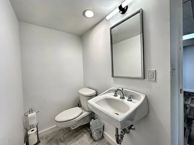 a bathroom with a toilet a sink and mirror