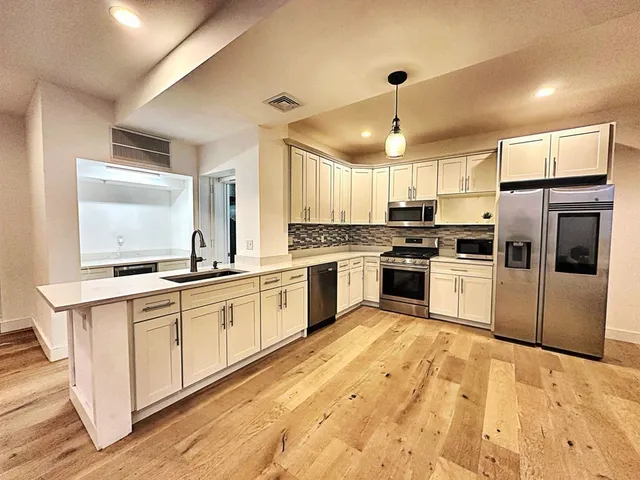 a kitchen with white cabinets stainless steel appliances and sink