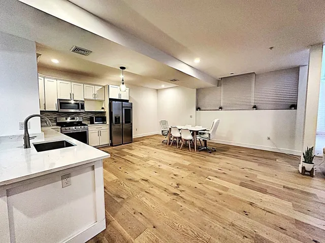 a kitchen with kitchen island a stove a counter top space and cabinets