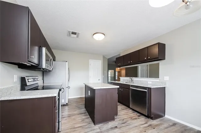 a kitchen with stainless steel appliances granite countertop a sink stove and microwave