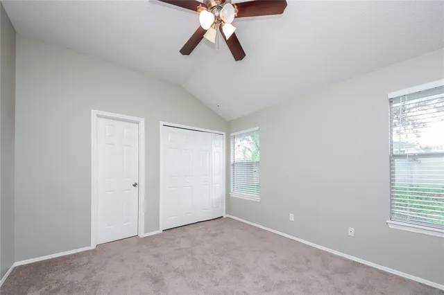 an empty room with windows and fan