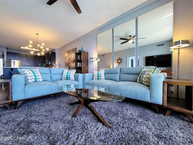 a living room with furniture and a chandelier