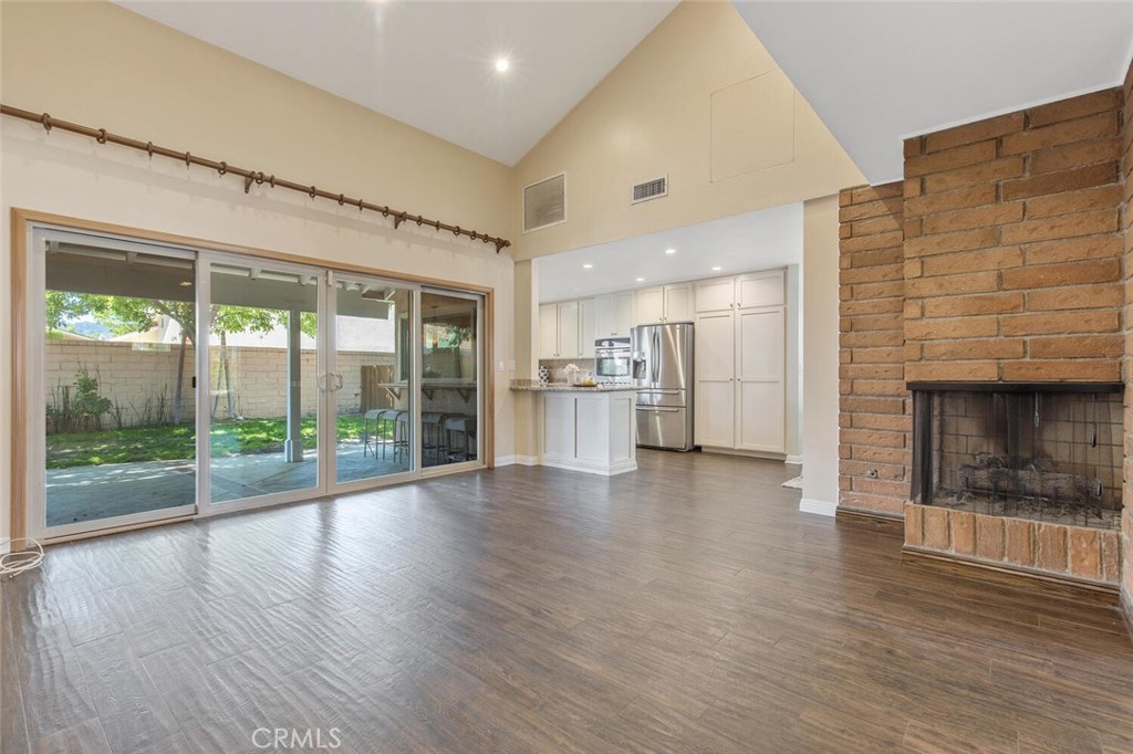23950 Avenida Crescenta Valencia, CA 91355 - Photo 11 of 44 an empty room with wooden floor and a fireplace