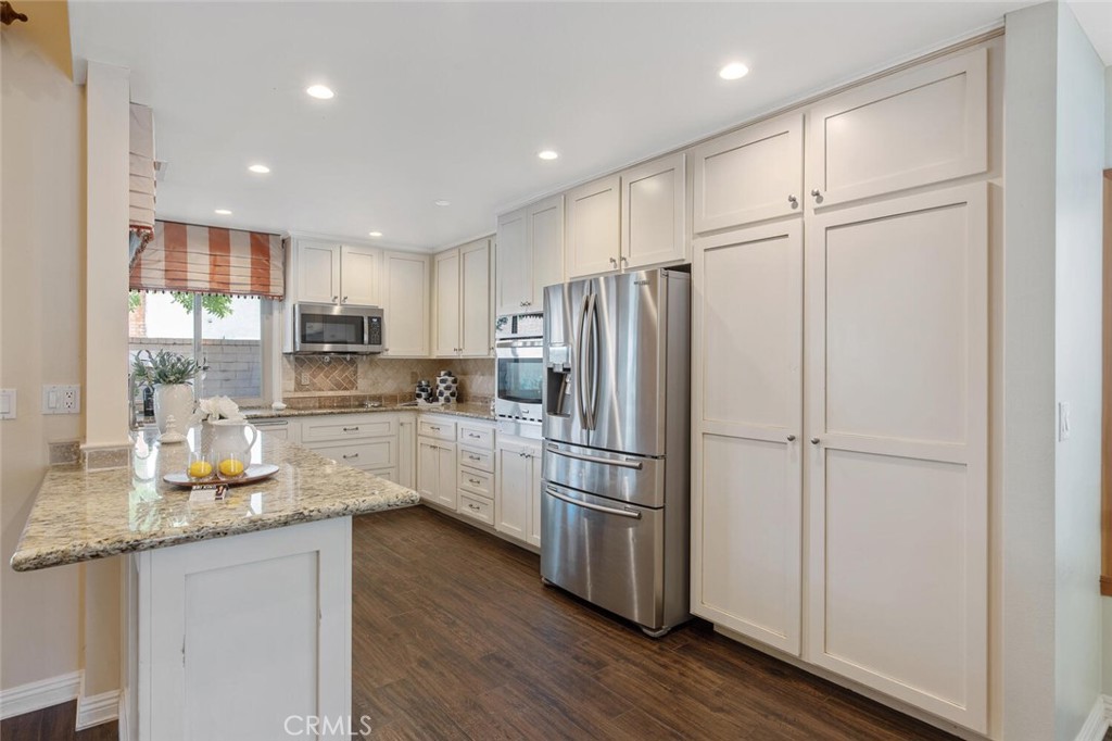 23950 Avenida Crescenta Valencia, CA 91355 - Photo 15 of 44 a kitchen with refrigerator cabinets and wooden floor
