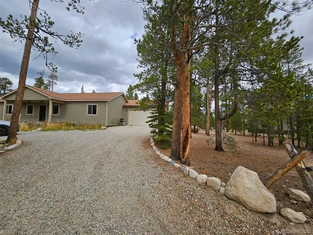 a front view of a house with a yard and trees