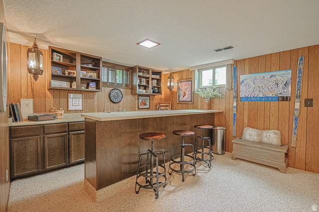 2924 Robidoux Road Sandy, UT 84093 - Photo 51 of 68 Built-in wet bar with a light-toned countertop, wood-paneled walls, built-in open shelving, and recessed lighting