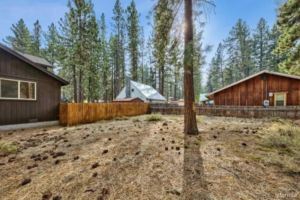 a backyard of a house with wooden fence and porch