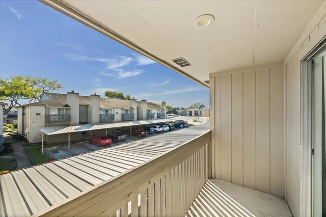 a view of a balcony with wooden floor and iron stairs