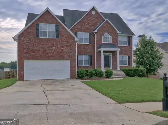 a front view of a house with a yard and garage