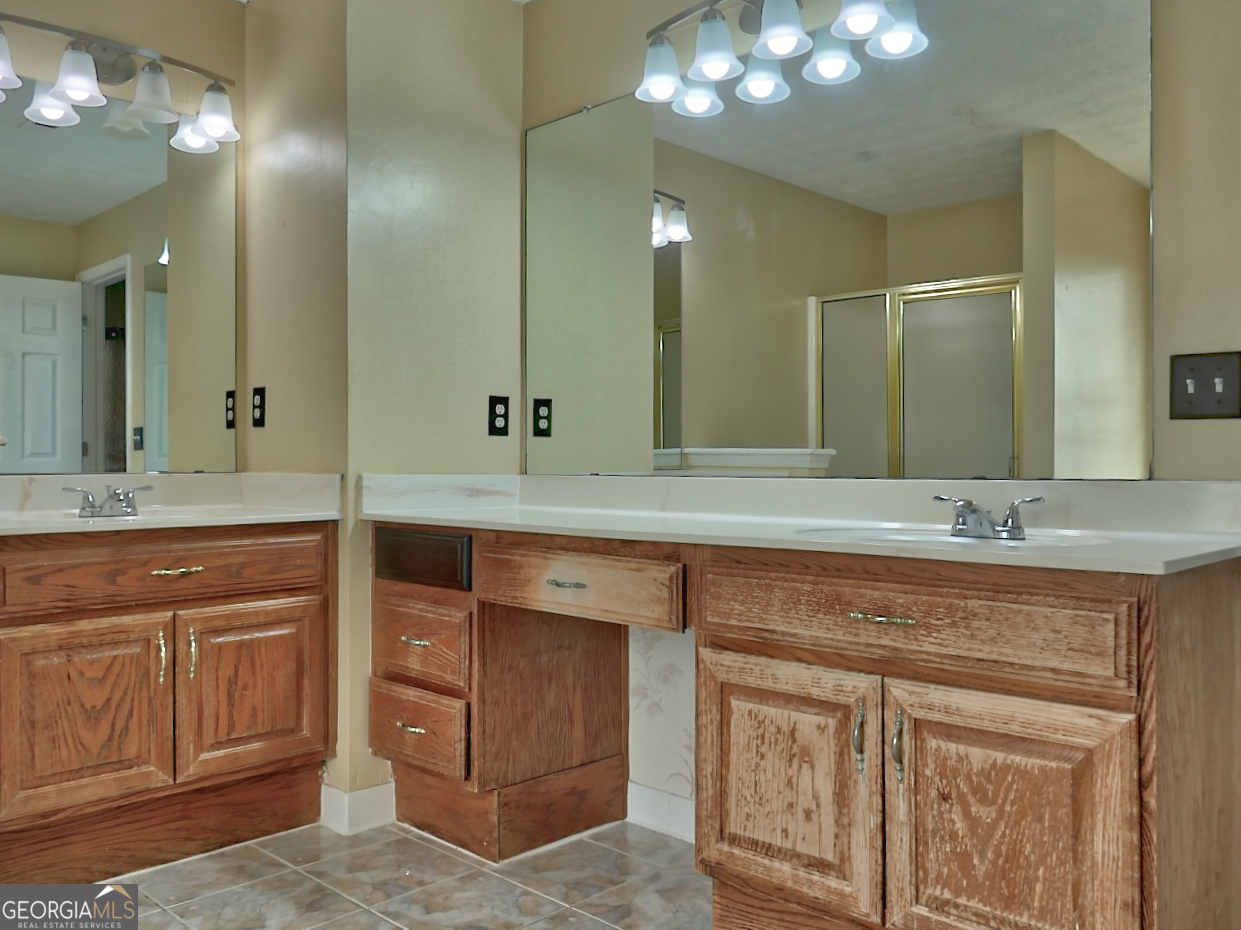 512 Chaucer Way Stockbridge, GA 30281 - Photo 18 of 25 a bathroom with a double vanity sink and a mirror