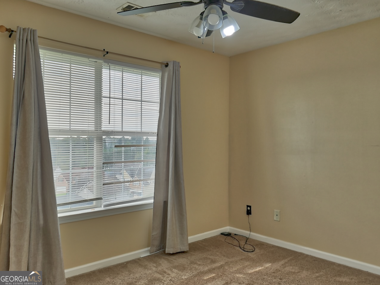 512 Chaucer Way Stockbridge, GA 30281 - Photo 19 of 25 an empty room with a chandelier fan