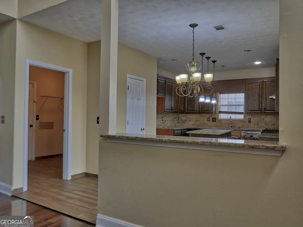 512 Chaucer Way Stockbridge, GA 30281 - Photo 9 of 25 a view of a kitchen with granite countertop cabinets and a wooden floor