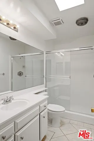 a bathroom with a granite countertop sink a toilet and shower