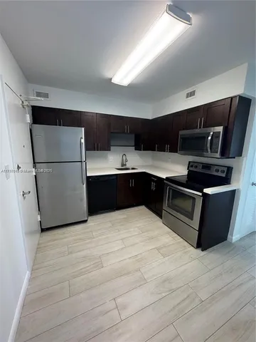 a kitchen with stainless steel appliances granite countertop a refrigerator and a stove top oven