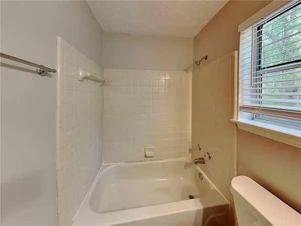 a white bath tub sitting next to a toilet