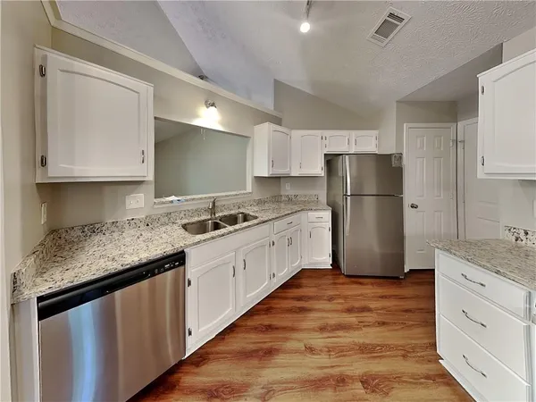 a kitchen with white cabinets and white appliances