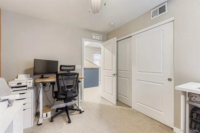 a view of a workspace with furniture and a window