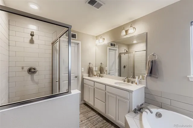a bathroom with a double vanity sink mirror and shower