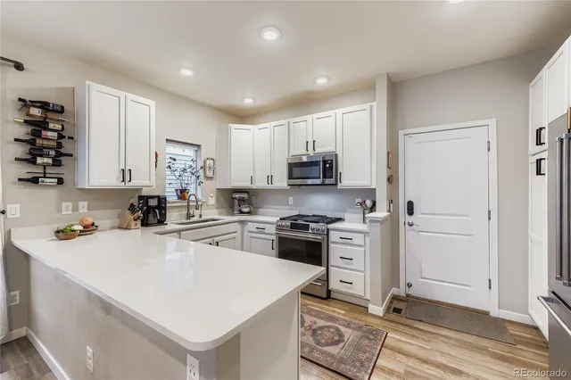 a kitchen with a sink a stove a refrigerator and cabinets