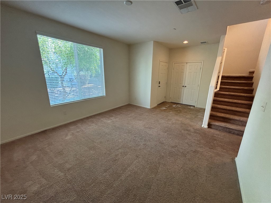 4512 Townwall Street Las Vegas, NV 89115 - Photo 12 of 56 Unfurnished living room featuring carpet flooring, stairway, and recessed lighting