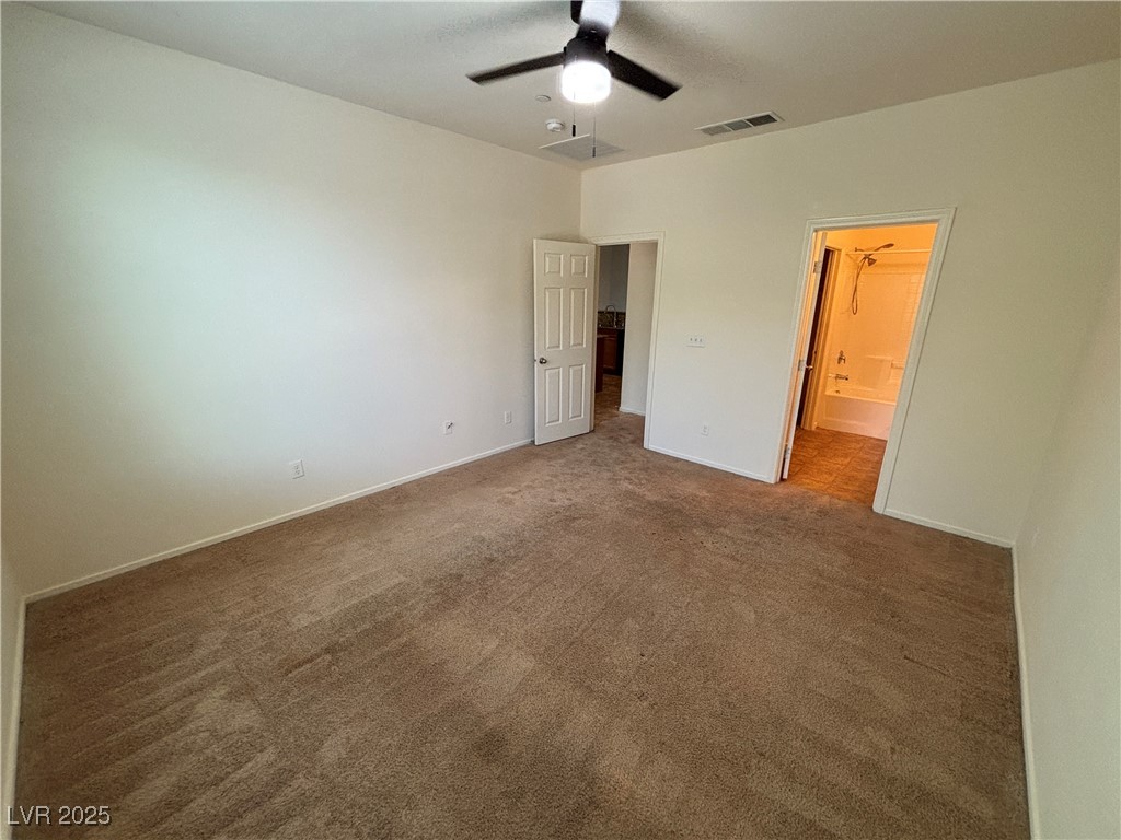 4512 Townwall Street Las Vegas, NV 89115 - Photo 27 of 56 Unfurnished bedroom with dark colored carpet, a ceiling fan, and connected bathroom