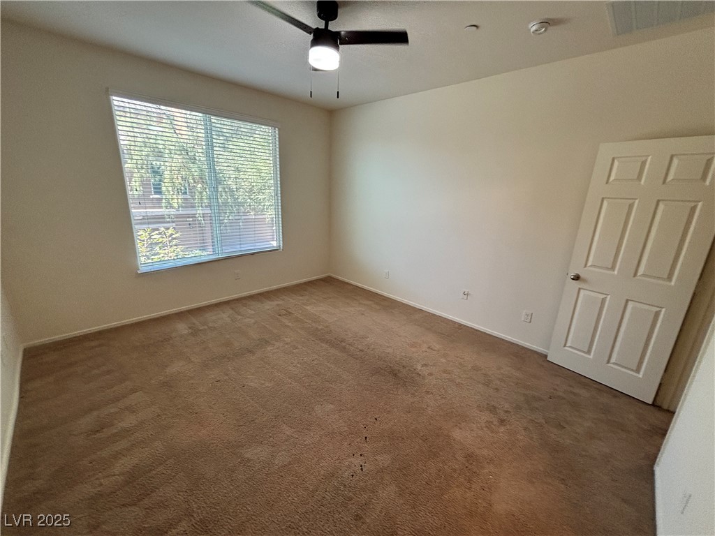 4512 Townwall Street Las Vegas, NV 89115 - Photo 28 of 56 Empty room featuring dark colored carpet and a ceiling fan