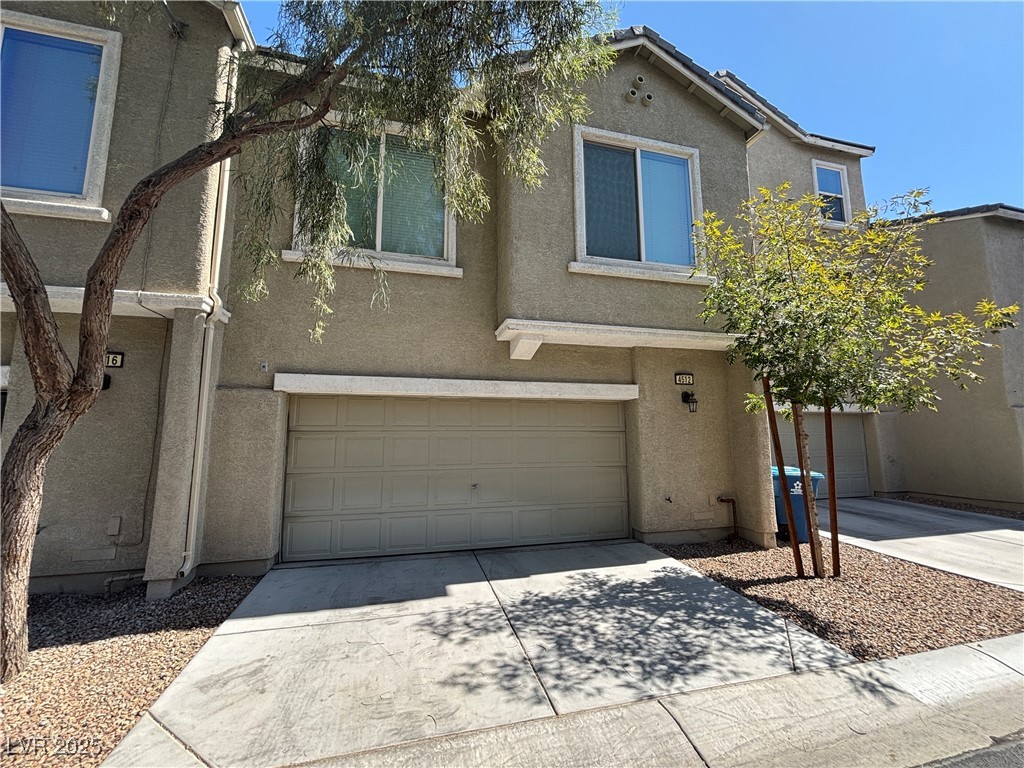 4512 Townwall Street Las Vegas, NV 89115 - Photo 3 of 56 Traditional-style home featuring stucco siding, concrete driveway, and a garage