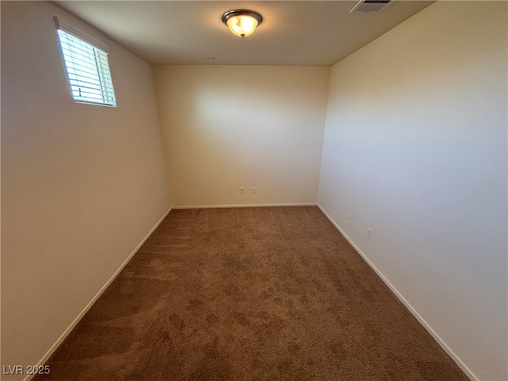 4512 Townwall Street Las Vegas, NV 89115 - Photo 39 of 56 Spare room with dark colored carpet and baseboards