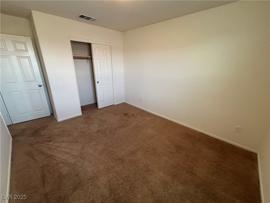 4512 Townwall Street Las Vegas, NV 89115 - Photo 50 of 56 Unfurnished bedroom featuring dark carpet and a closet