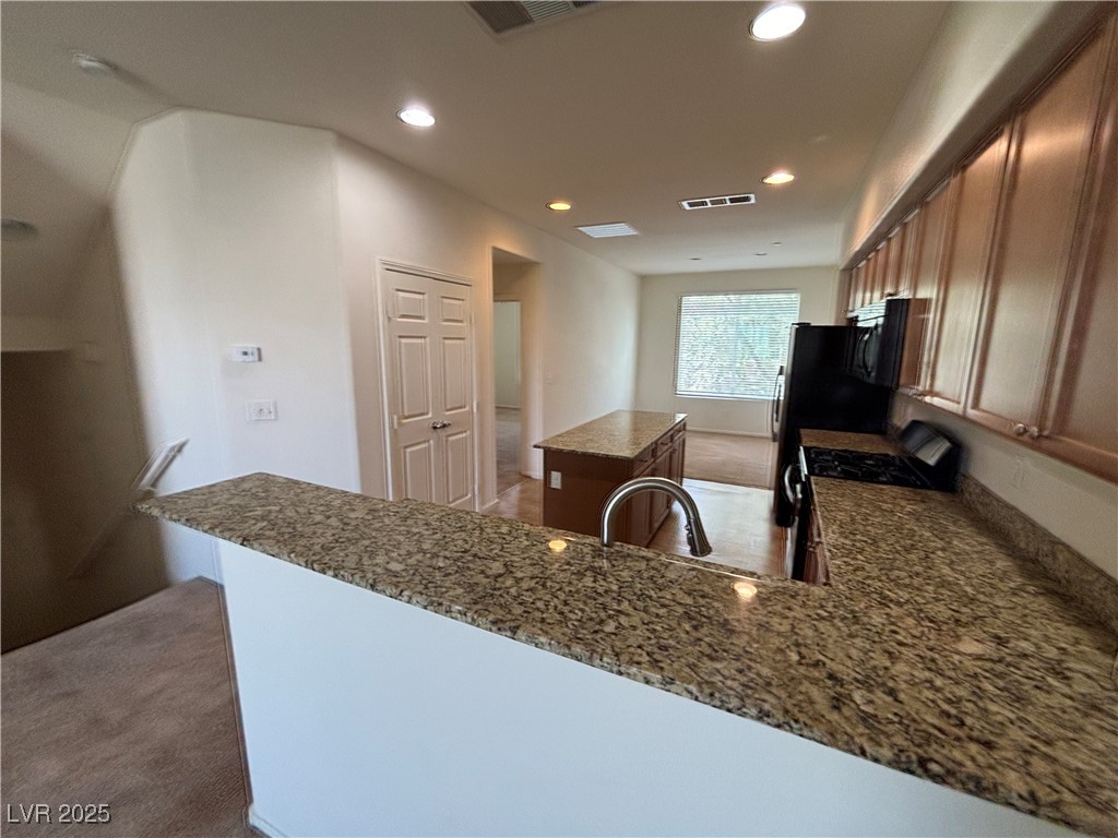 4512 Townwall Street Las Vegas, NV 89115 - Photo 52 of 56 Kitchen featuring a center island, range with gas stovetop, dark carpet, recessed lighting, and a peninsula
