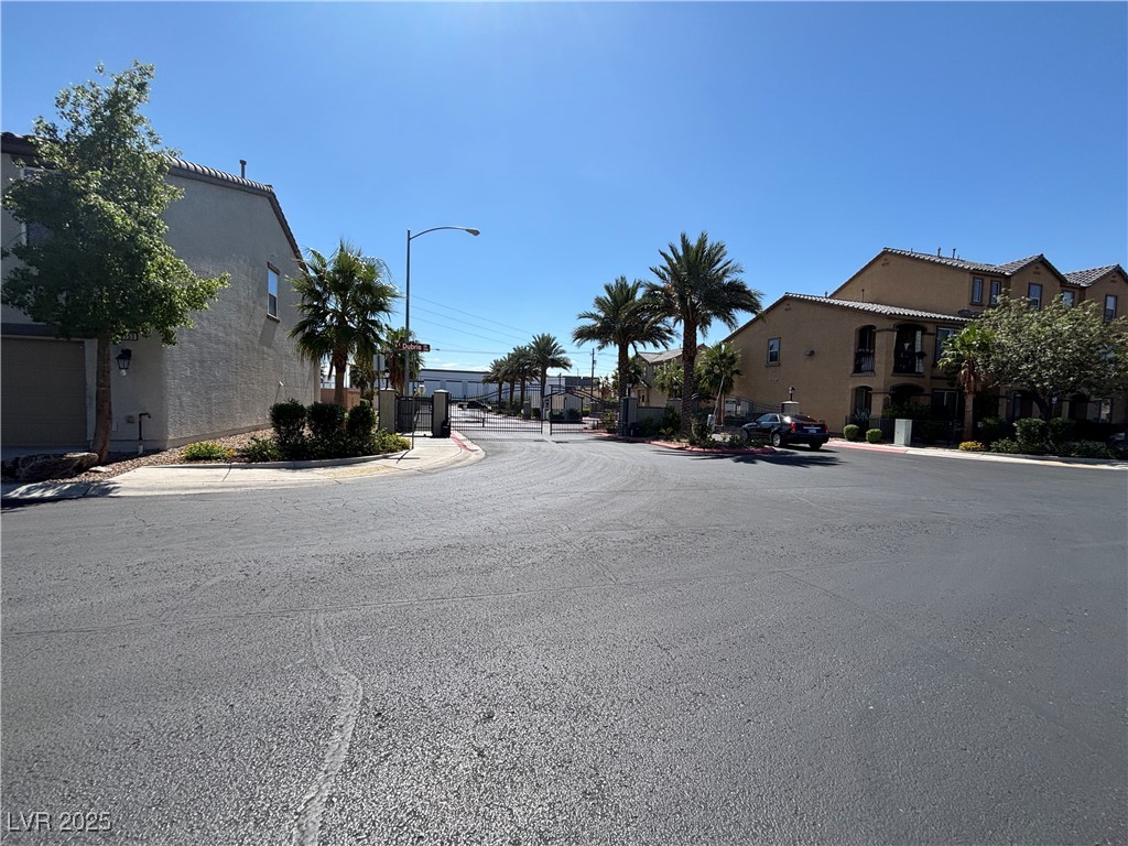 4512 Townwall Street Las Vegas, NV 89115 - Photo 55 of 56 View of asphalt street with sidewalks, curbs, street lighting, a gated entry, and a residential view
