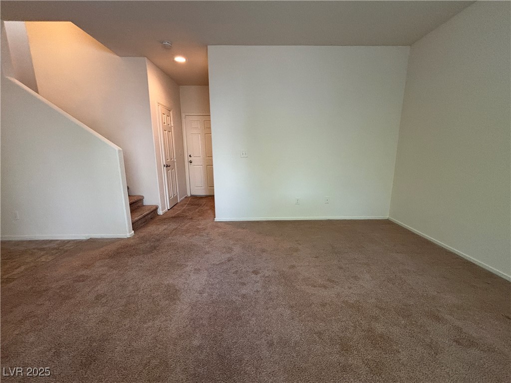 4512 Townwall Street Las Vegas, NV 89115 - Photo 10 of 56 Unfurnished living room with dark carpet, stairs, and recessed lighting