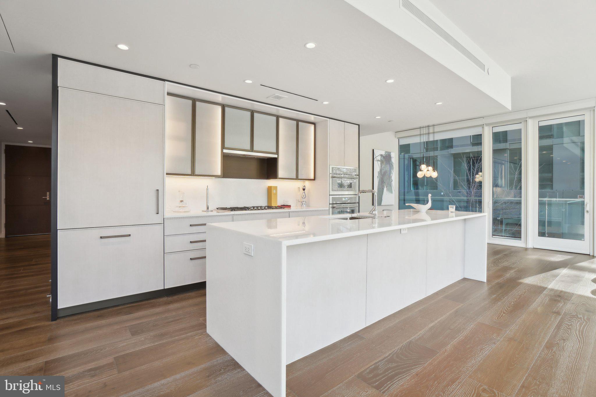 601 Wharf Street Southwest, Unit 213 Washington, DC 20024 - Photo 5 of 23 a kitchen with kitchen island granite countertop a sink and cabinets