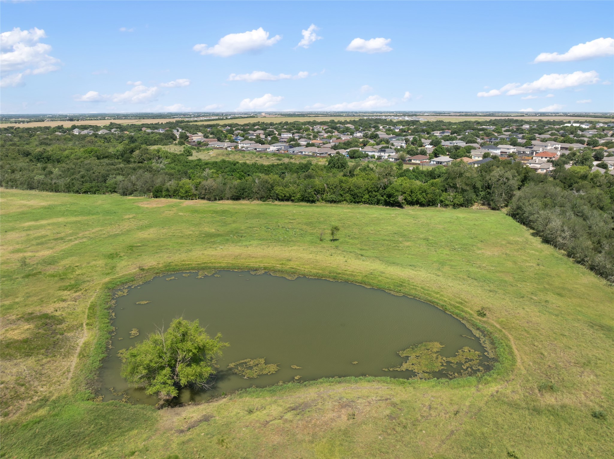 12500 County Line Road Elgin, TX 78621 - Photo 6 of 9 Aerial view of a nearby body of water and a tree filled landscape
